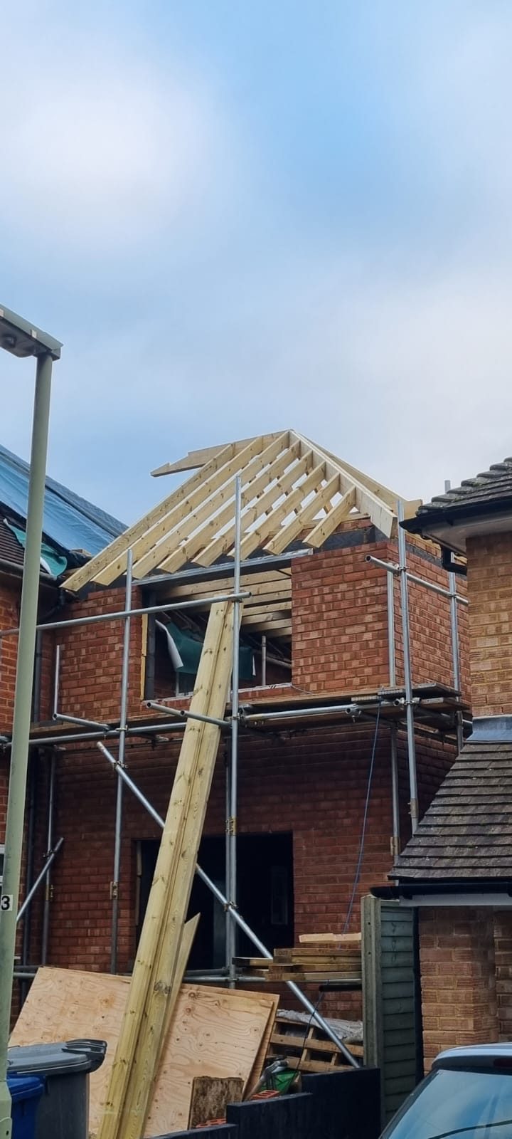 Two-storey house extension under construction with new roof structure