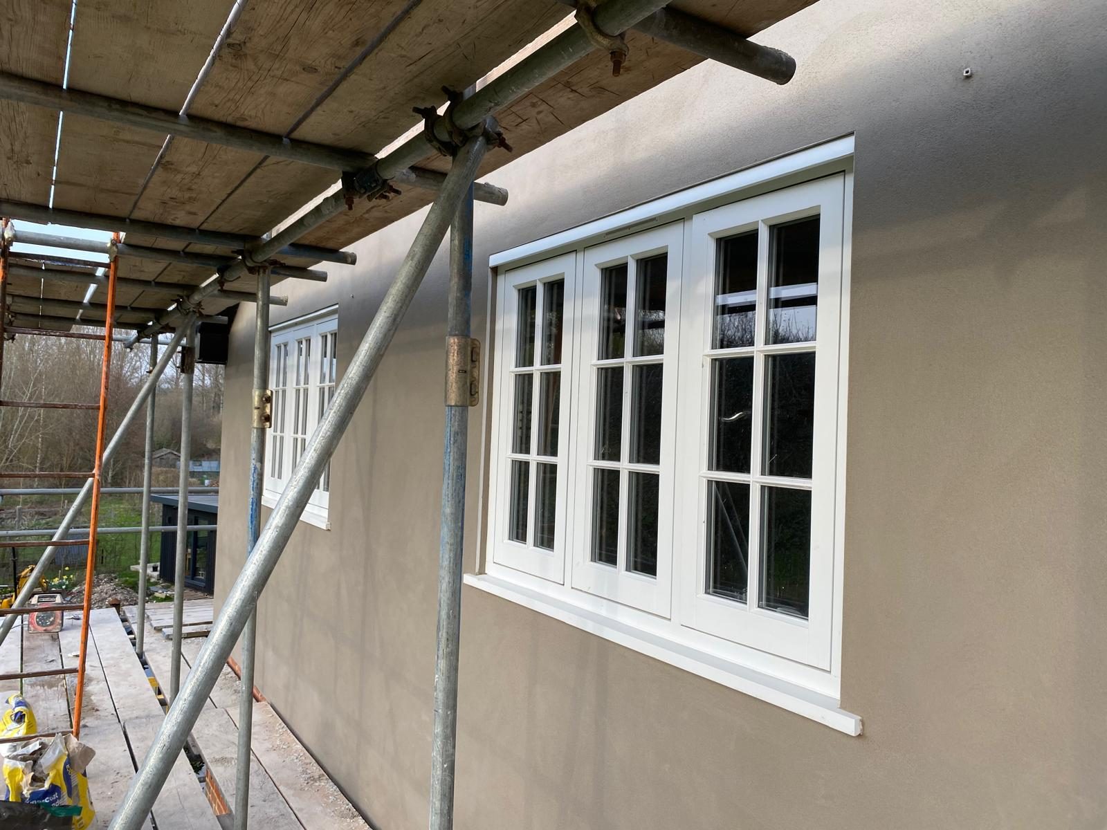 Rendered extension wall with new timber casement windows installed