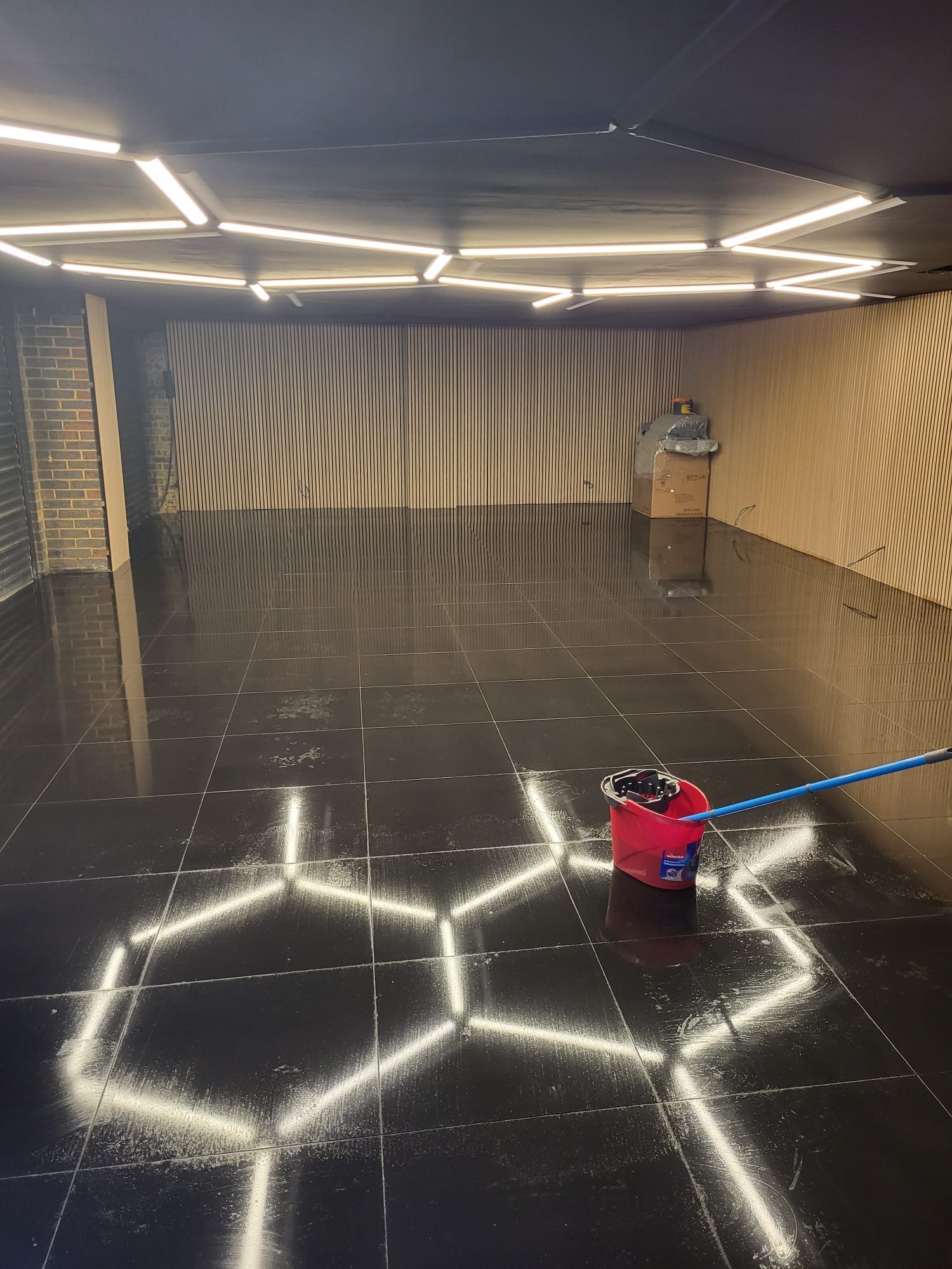Completed garage conversion with tiled floor, panelled walls and feature lighting