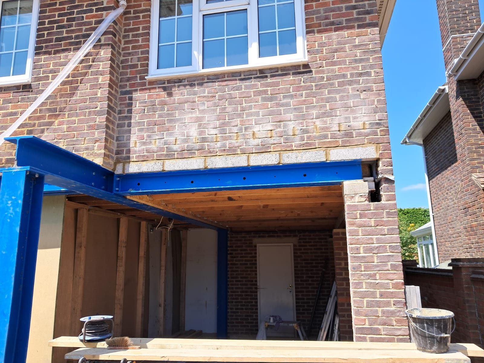 Steel RSJ beam installed over a wide structural opening in a brick wall