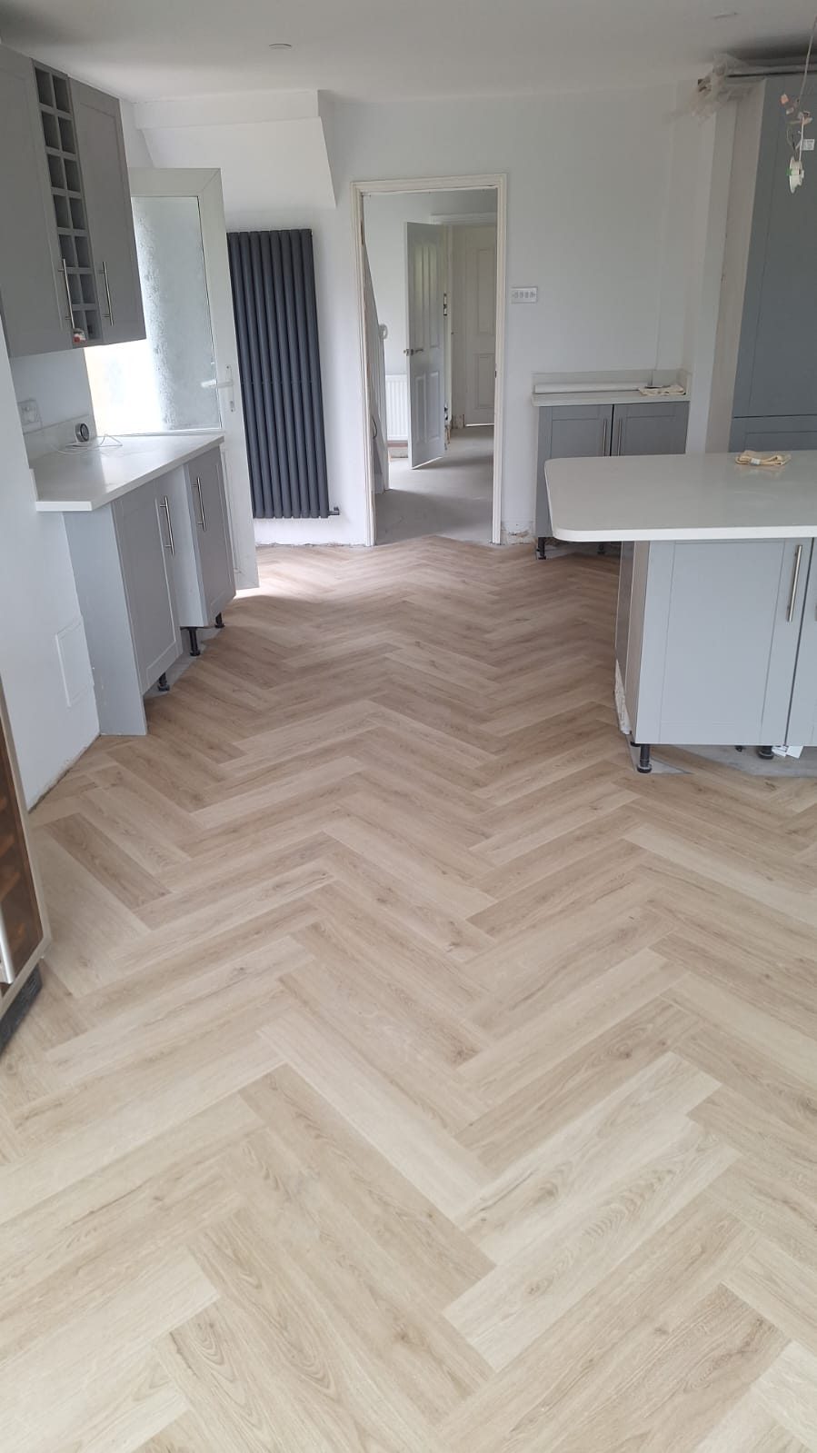 Herringbone flooring and grey kitchen units in a refurbished home