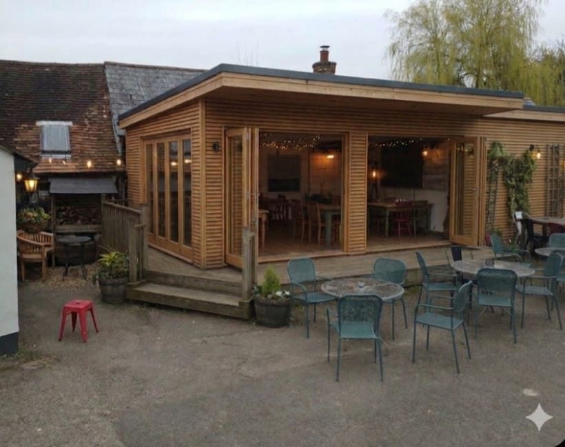 Timber-clad garden room with bi-fold doors and decked terrace