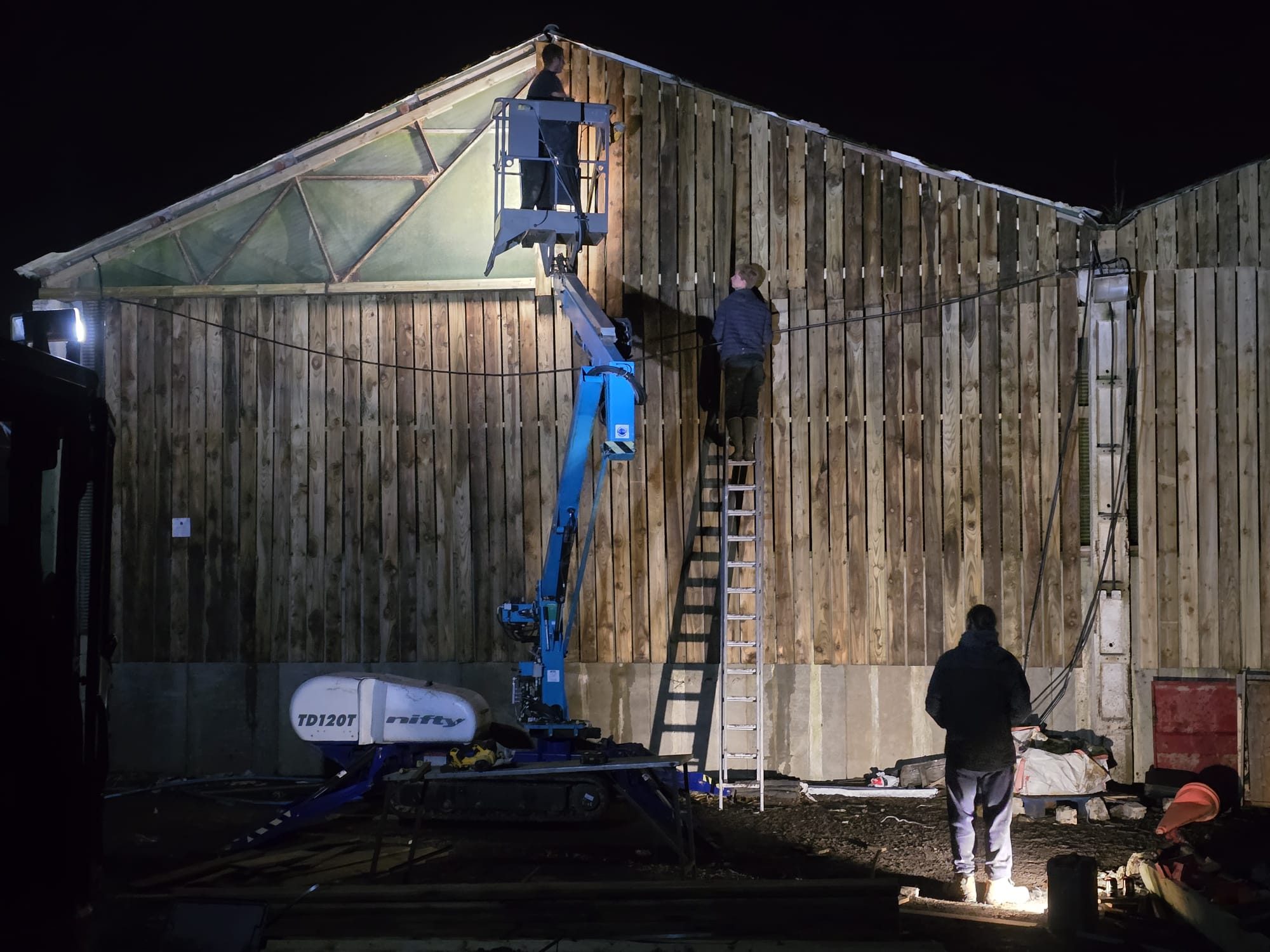 Timber cladding being installed on a large insulated garden building